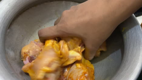 Hand-Mixing-And-Marinating-Raw-Chicken-Leg-Pieces-Inside-Metal-Bowl