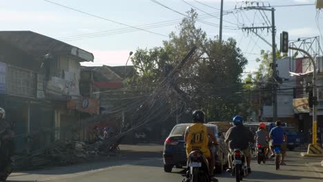 Fahrzeuge-Fahren-Auf-Der-Straße-Mit-Umgestürzten-Strommasten-Und-Stromleitungen,-Verursacht-Durch-Den-Taifun-Odette-Auf-Den-Philippinen