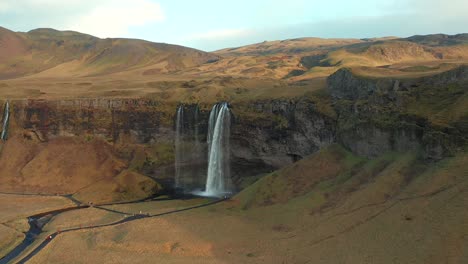Aerial-view-of-Seljalandsfoss-waterfall-in-Iceland,-dolly-in-close-up-drone-shot,-famous-cascade-landscape