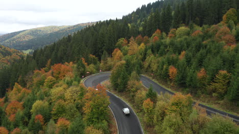 Aerial-Following-Cars-Driving-and-Turning-on-a-Bended-Road-Through-the-Beautiful-Mixed-Colorful-Autumn-Forest-in-Romania-Mountains