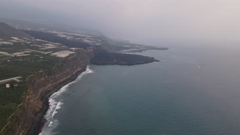 Aerial-forward-along-coast-and-solidified-lava-flowed-in-sea-after-eruption