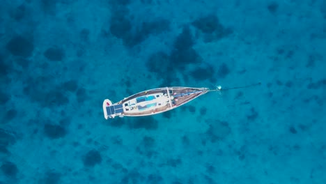 Yacht-swaying-and-bobbing-in-the-ocean-revealing-reef-in-the-clear-blue-waters