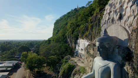 Giant-Buddha-rock-carving-in-the-side-of-mountain,-Phnom-Sampov,-Battambang,-Cambodia