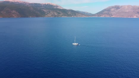 Aerial-view-near-the-Antisamos-beach-with-clear-water-and-sailing-boat
