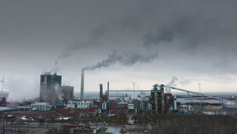 AERIAL-EPIC-Apocalyptic-shot-of-a-factory-with-chimneys-billowing-out-smoke