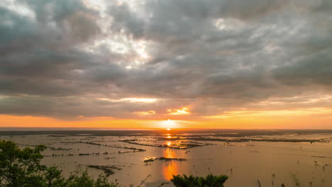 Golden-sunset-reflection-over-the-horizon-of-receding-Tonle-Sap-Lake-fertile-water,-revealing-sunken-paddy-fields-at-the-end-of-rainy-season