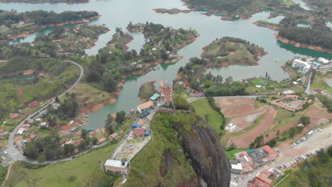 Flying-above-a-large-granite-rock-called-The-Rock-of-Guatape-in-Antioquia,-Colombia---aerial-drone-shot