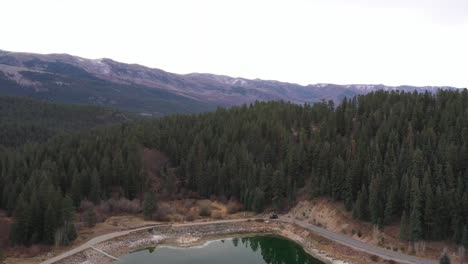 Rocky-Mountains-with-calm-lake.-Drone-moving-down