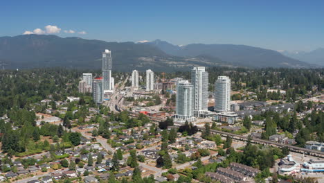 Aerial-View-Of-Area-Around-Burquitlam-Station-In-Coquitlam,-British-Columbia,-Canada-With-Mountainous-Landscape-In-Background