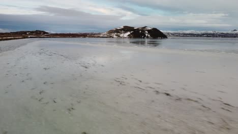 Drone-De-Vuelo-Aéreo-Bajo-Sobre-Lago-Congelado-A-Volcán-En-Islandia