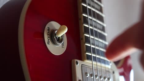 The-pick-up-switch-of-a-red-electric-Les-Paul-guitar-being-switched-from-treble-to-rhythm