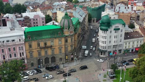 Antiguo-Banco-Rodeado-De-Antiguos-Edificios-Históricos-Europeos-Con-Coches-Circulando-Por-Las-Calles-De-Lviv,-Ucrania
