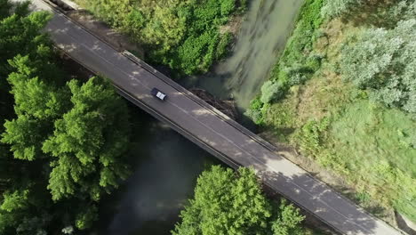 Einsames-Auto-überquert-Eine-Flussbrücke-In-Einer-Tropischen-Ländlichen-Gegend
