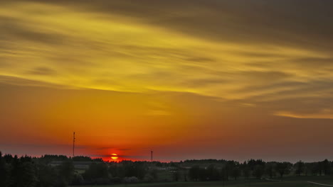 Malerische-Landschaft-Mit-Orangefarbenem-Sonnenuntergang-Hinter-Waldbäumen-Und-Fliegenden-Weichen-Wolken-Am-Abendhimmel---Zeitraffer-Panoramablick