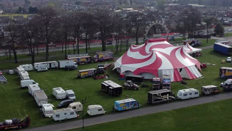Planet-circus-daredevil-entertainment-colourful-swirl-tent-and-caravan-trailer-ring-aerial-view-wide-rising-orbit-right