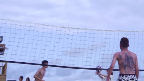 Asian-guy-hits-volleyball-over-to-opposing-team-and-grabs-net-and-Asian-woman-fails-to-return-filmed-in-slow-motion