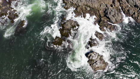 Aerial-push-in-and-tilt-up-over-crashing-waves-on-the-rocky-Sea-Ranch,-California-coast
