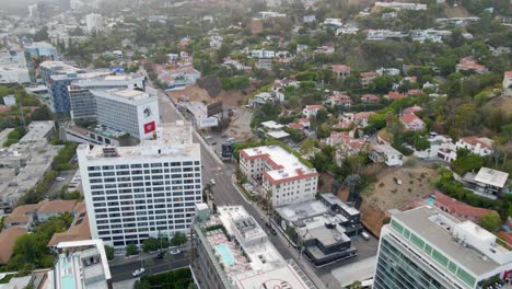 Aerial-view-of-traffic-on-the-Sunset-Blvd,-sunny-evening,-in-west-Hollywood---pan,-drone-shot