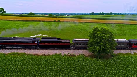 Eine-Parallele-Luftaufnahme-Eines-Antiken-Dampf-Personenzuges,-Der-Schwarzen-Rauch-Durch-Das-Ackerland-Von-Pennsylvania-Bläst