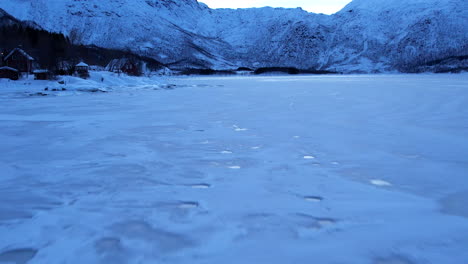 Frozen-icy-Fjord-in-Norway---low-flyover,-harsh-winter-landscape