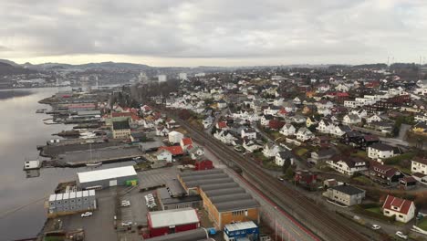 Industrial-area-along-Sorlandsbanen-and-Sandnes-harbour---Aerial-moving-sideways-over-sortoget-railway-looking-towards-Sandnes-city-center---Norway