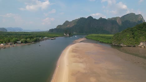 drone-revealing-a-kayak-on-a-sandbar-surrounded-by-a-river-and-mangroves-on-a-sunny-day-in-Ao-Thalane-Krabi-Thailand-with-mountains-in-the-distance