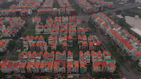 Imágenes-De-Drones-De-Madrugada-Con-Niebla-Y-Smog-Que-Vuelan-Hacia-Atrás-Sobre-Urbanizaciones-Urbanas-De-Gran-Altura-Y-Villas-En-El-Distrito-Siete-De-Saigón,-Ciudad-De-Ho-Chi-Minh,-Vietnam