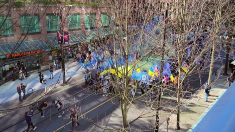 Ukrainische-Demonstranten-Marschieren-Bei-Einer-Kundgebung-In-Der-Innenstadt-Von-Vancouver-Mit-Blauen-Und-Gelben-Rauchbomben