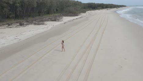 Female-Tourist-In-Bikini-Walking-On-White-Sand-Beach-In-North-Straddie-In-Queensland