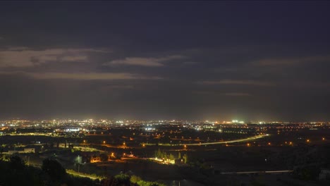 Nachtzeitraffer-Der-Stadtlandschaft-Mit-Blitzen-Im-Hintergrund