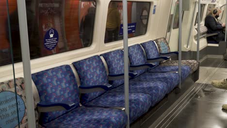 Reihe-Leerer-Sitze-Im-Jubilee-Line-Zug-Der-Londoner-U-Bahn,-Der-Den-Bahnsteig-Verlässt