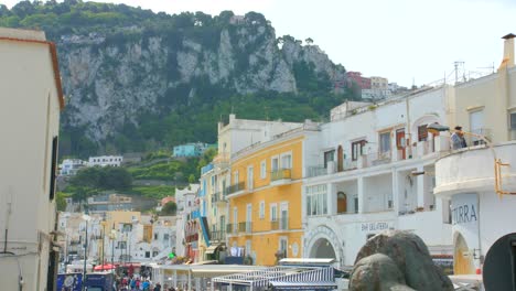 Overlooking-Marina-Grande-with-colorful-houses,-people-and-mountains-in-the-background-in-Capri,-Italy