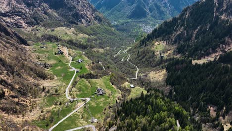 Camino-Torcido-A-Través-De-Un-Pequeño-Pueblo-Aislado-En-El-Valle-Alpino-Italiano---Drone