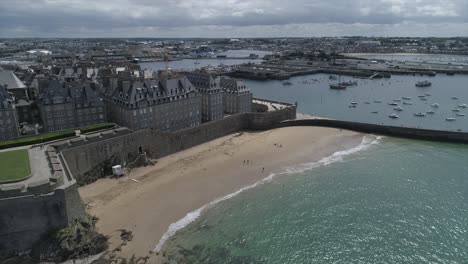 Drone-footage-of-the-beach,-the-sea,-the-port-and-the-Wall-of-Saint-Malo,-Bretagne,-France
