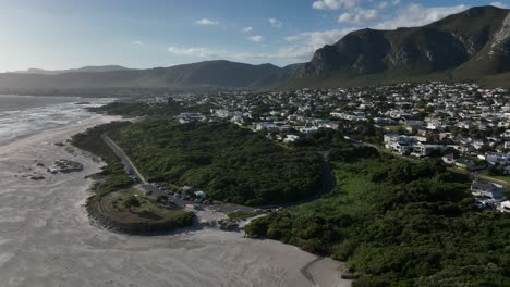 A-dynamic-descending-aerial-footage-of-the-famous-kitesurfing-spot-in-Hermanus,-looking-on-the-west,-in-South-Africa