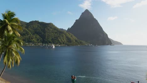 Sonniger-Tag-In-Der-Karibik-Mit-Palmenstrand-Und-Berggipfeln-Im-Hintergrund
