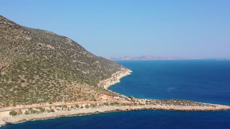 aerial-drone-of-a-coastal-road-along-the-dark-blue-Mediterranean-Sea-in-Kas-Turkey-on-a-sunny-summer-day