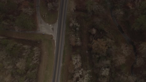 An-empty-highway-road-surrounded-by-trees-in-late-fall