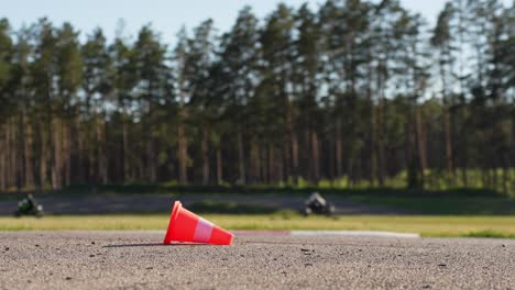 Traffic-Cone-on-the-Road-with-Motorcycles-Racing-in-Background