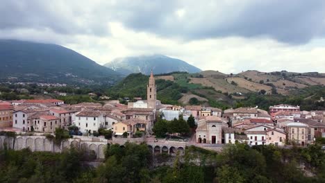 Aerial-dolly-out-revealing-a-small-Italian-town-in-a-mountain-landscape