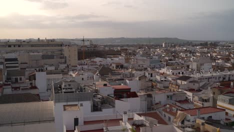 High-above-slow-motion-pan-across-cityscape-of-Seville,-Spain