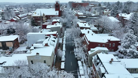 American-town-during-winter-snow-aerial-in-evenign