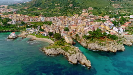 Aerial-forwarding-shot-of-amazing-landscape-of-Sicily-along-the-beautiful-coastal-town-of-Caletta-Sant'Elia,-Santa-Flavia-PA,-Italy-on-a-cloudy-day