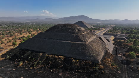 Teotihuacan-Mexico-Aerial-v4-low-level-fly-around-pyramid-of-the-moon,-capturing-avenue-of-the-dead-leading-to-pyramid-of-the-sun-and-beautiful-mountainscape---Shot-with-Mavic-3-Cine---December-2021