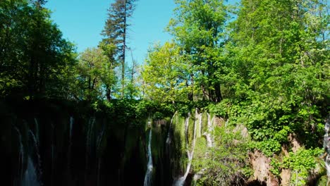 Drohnenaufstieg-über-Wasserfälle-Mit-Schwerpunkt-Auf-Einem-Großen-Türkisblauen-See-In-Einem-Kroatischen-Nationalpark