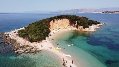 Tourist-People-Relax-at-Small-White-Sandy-Beach-at-Ksamil-Islands,-Albania---Aerial
