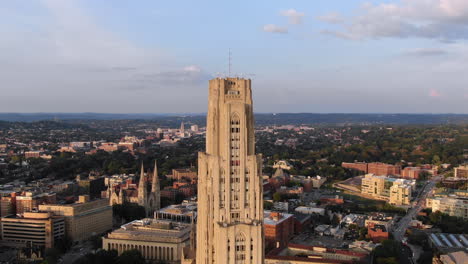 A-"zolly"-aerial-establishing-shot-of-the-top-of-the-Cathedral-of-Learning-in-Pittsburgh's-Oakland-district-on-an-early-summer-evening