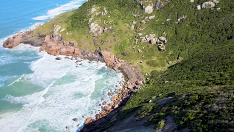 Aerial-drone-scene-of-deserted-secret-beach-between-mountains-open-sea-rocks-beach-in-Florianópolis