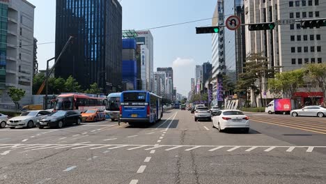 Driver's-POV-Driving-At-The-Main-Street-Of-Gangnam-Between-High-rise-Buildings-In-Seoul,-South-Korea