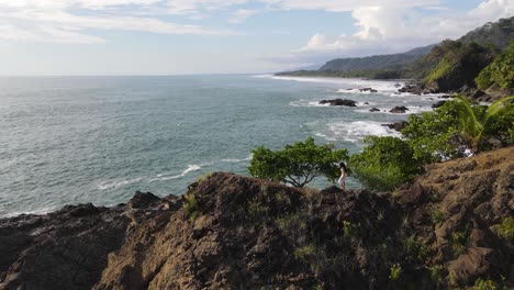 Lady-walking-on-cliff-edge-with-view-of-ocean-in-Costa-Rica